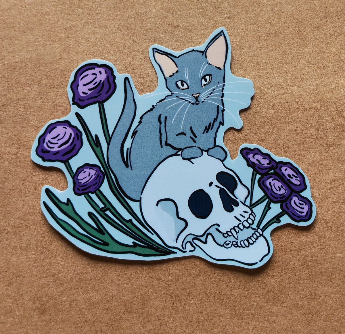 Grey cat sitting on skull sticker