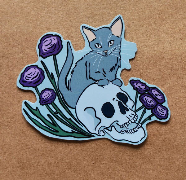 Grey cat sitting on skull sticker